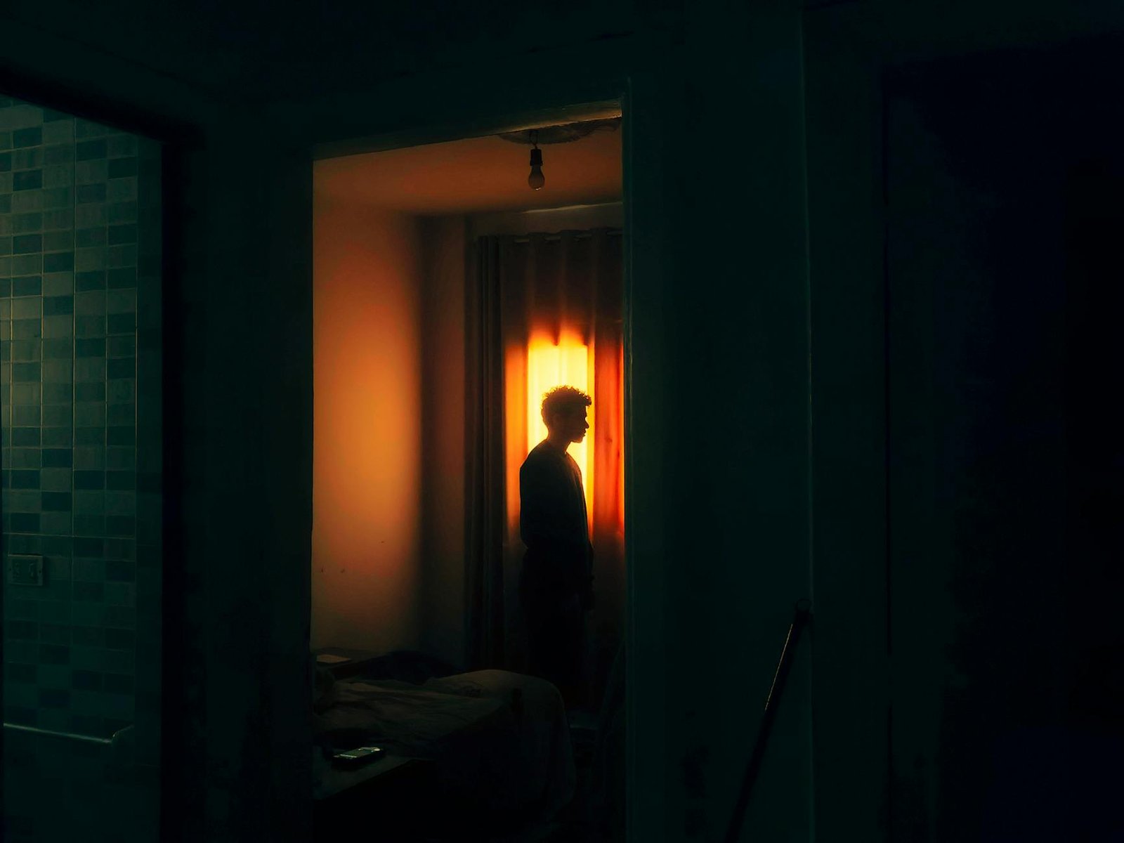 silhouette of a man in a dimly lit room
